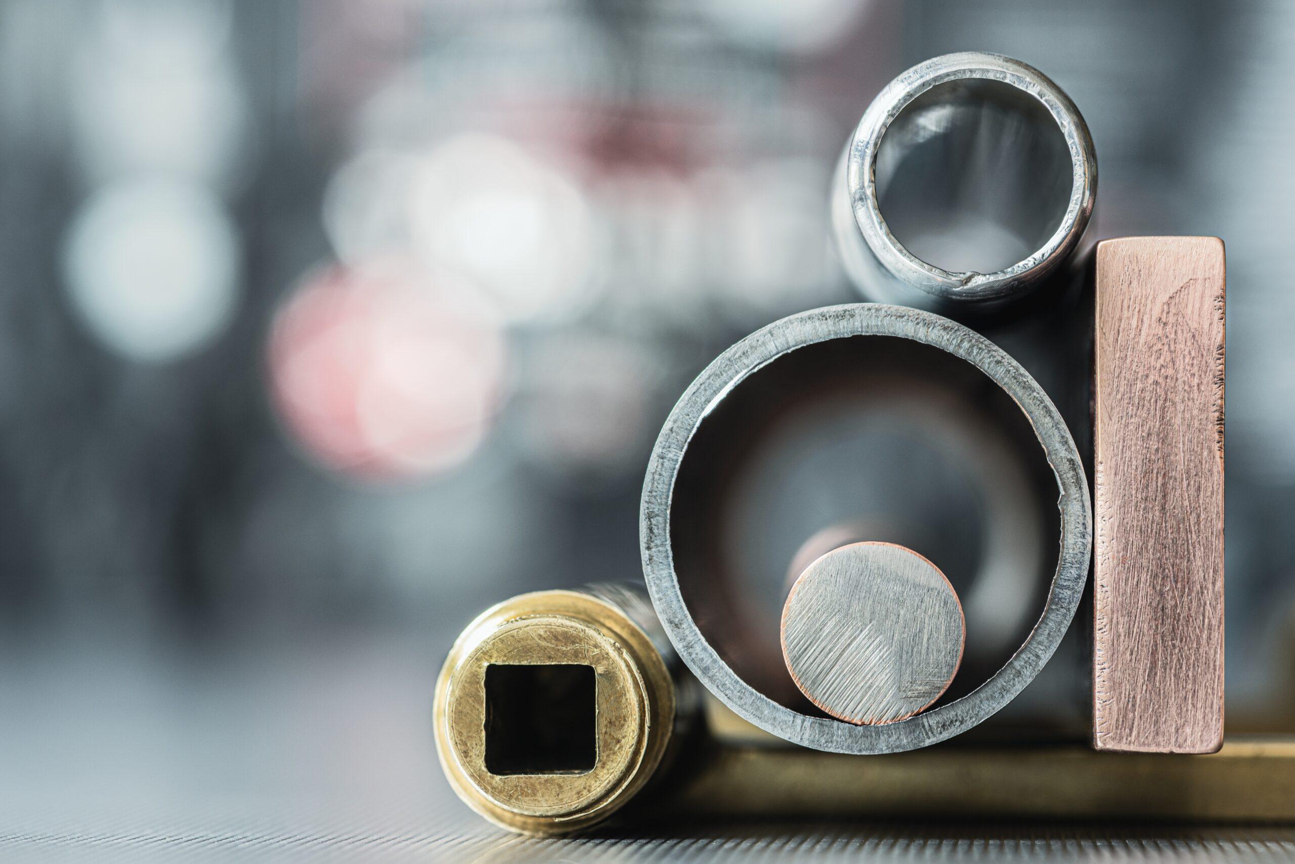 Close-up of assorted industrial metal pipes, tubes, and solid bars used in manufacturing, industrial supply chains, and international trade.